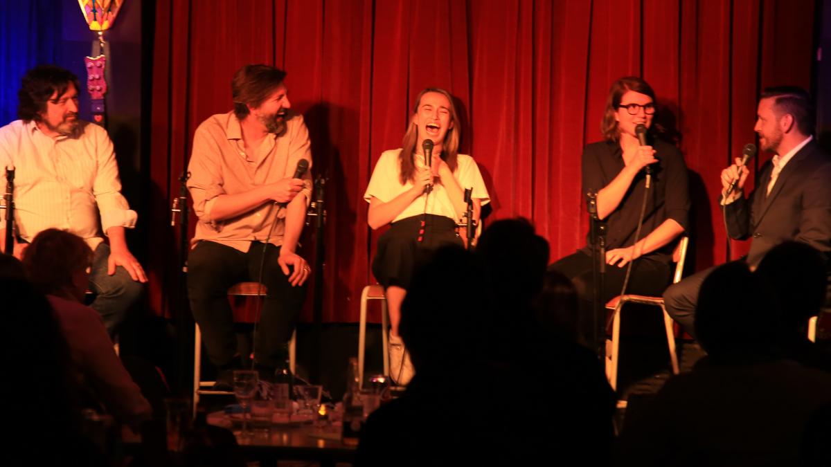 photo of people on stage laughing